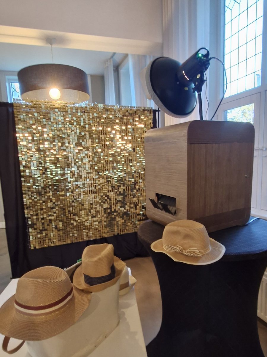Houten photobooth met gouden achtergrond in een trouwlocatie